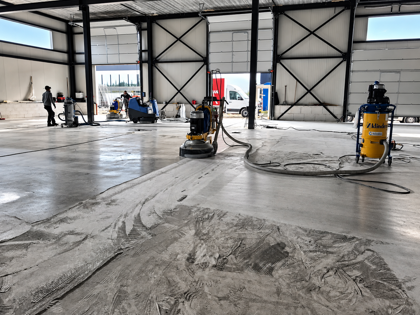 Betonvloer schuren en slijpen met stofafzuiging in bedrijfshal